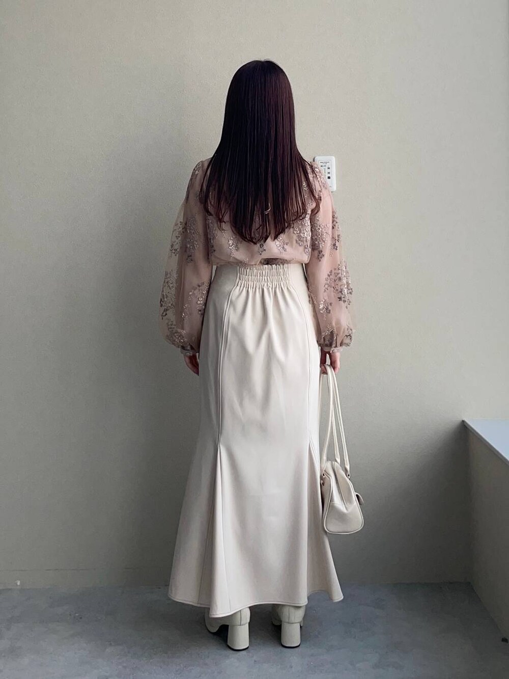 ピンク系のシャツ/ブラウス、ホワイト系のブーツ、ホワイト系のハンドバッグを着用したレディースの冬コーディネートの2枚目の写真