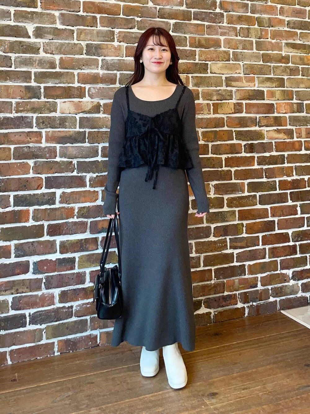 ブラック系のブルゾン、ホワイト系のブーツ、ブラック系のハンドバッグを着用したレディースの秋コーディネートの3枚目の写真