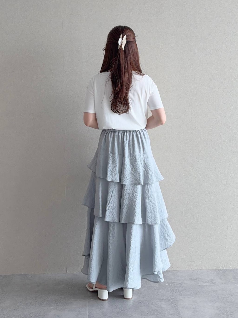 ホワイト系のTシャツ/カットソー、ホワイト系のショルダーバッグ、グレー系のスカートを着用したレディースの夏コーディネートの2枚目の写真