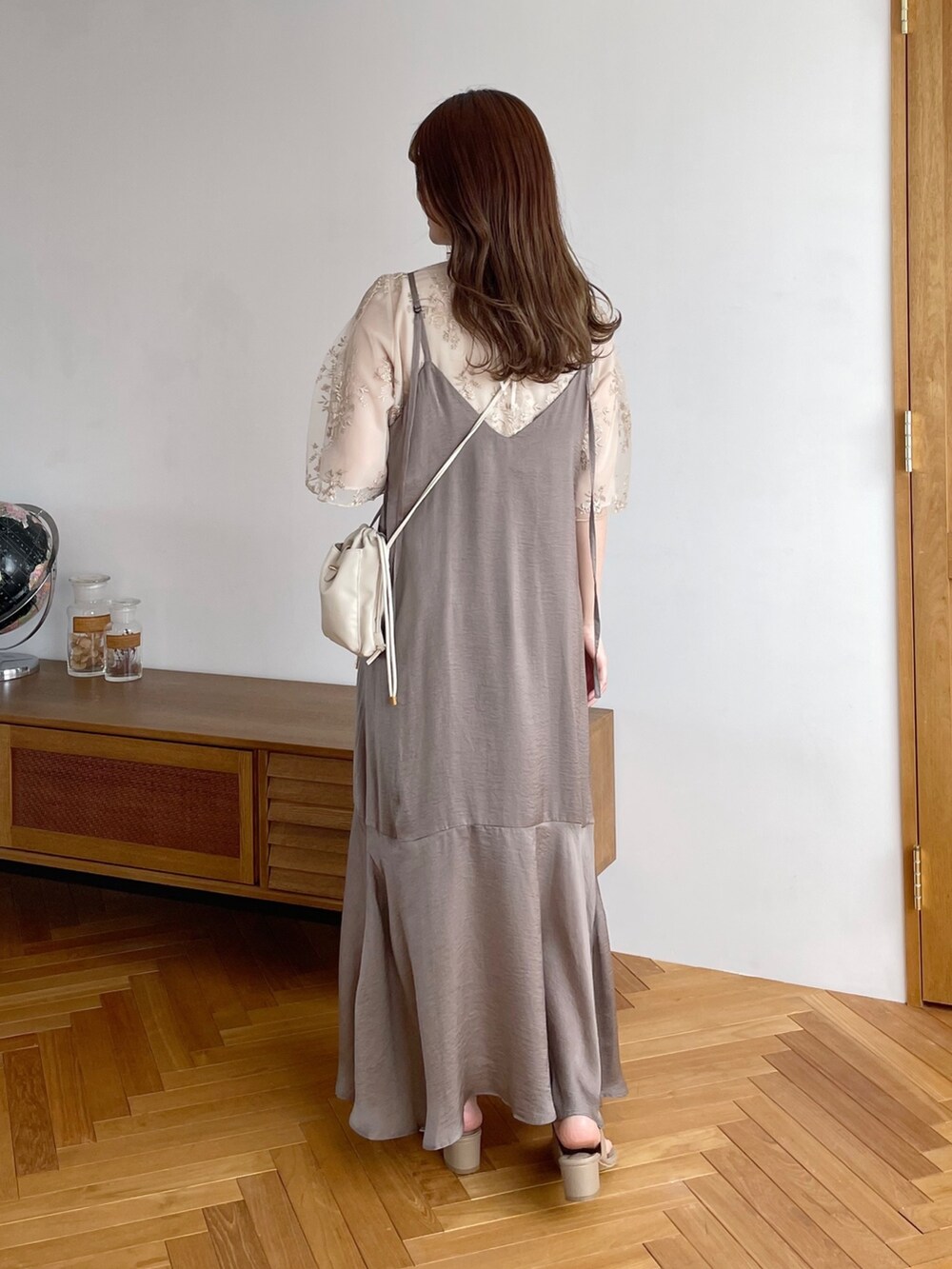 ホワイト系のシャツ/ブラウス、ベージュ系のワンピース、ホワイト系のショルダーバッグを着用したレディースの春コーディネートの2枚目の写真