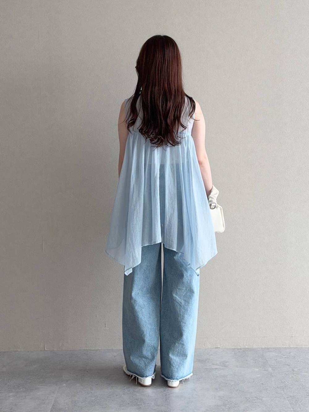ブルー系のシャツ/ブラウス、ブルー系のデニムパンツ、ホワイト系のショルダーバッグを着用したレディースの夏コーディネートの2枚目の写真
