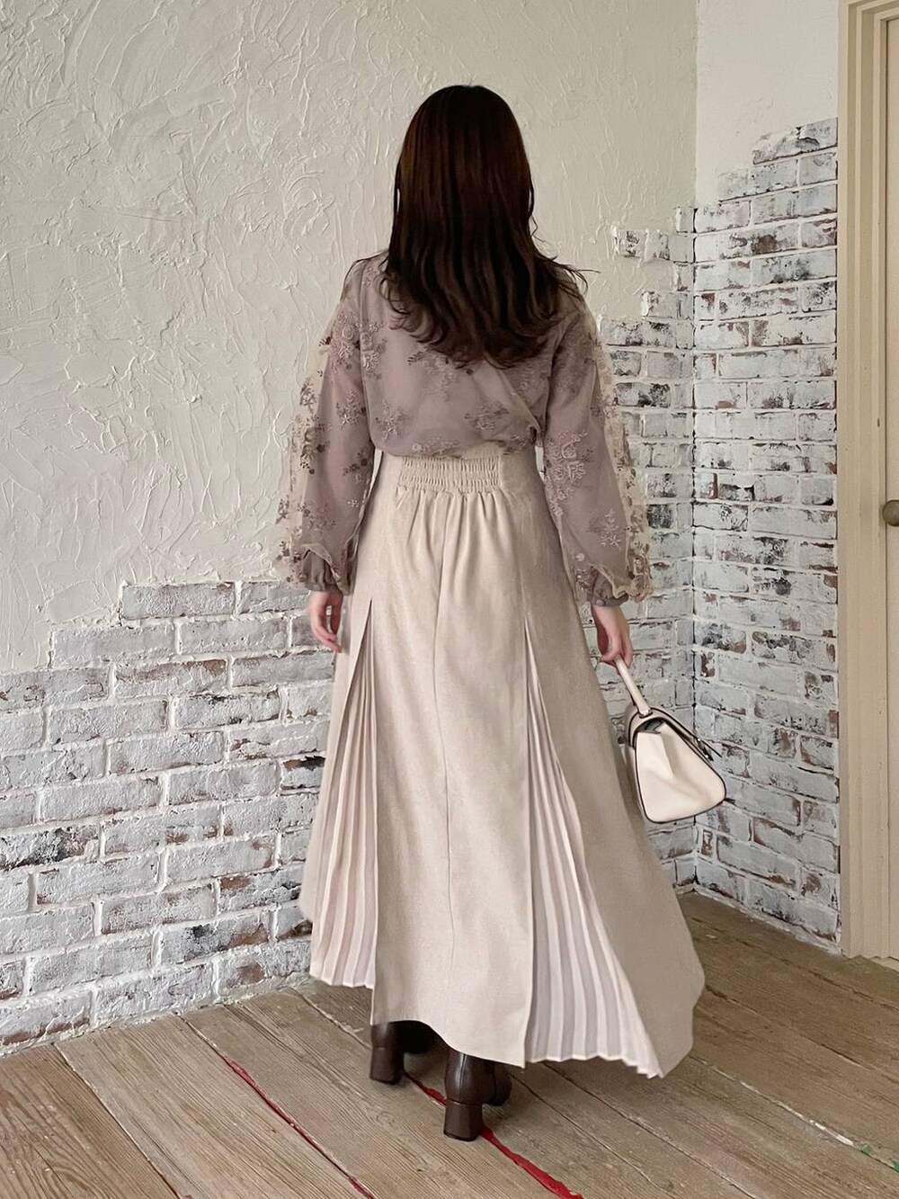 ホワイト系のハンドバッグ、ブラウン系のシャツ/ブラウス、ブラウン系のブーツを着用したレディースの秋コーディネートの2枚目の写真