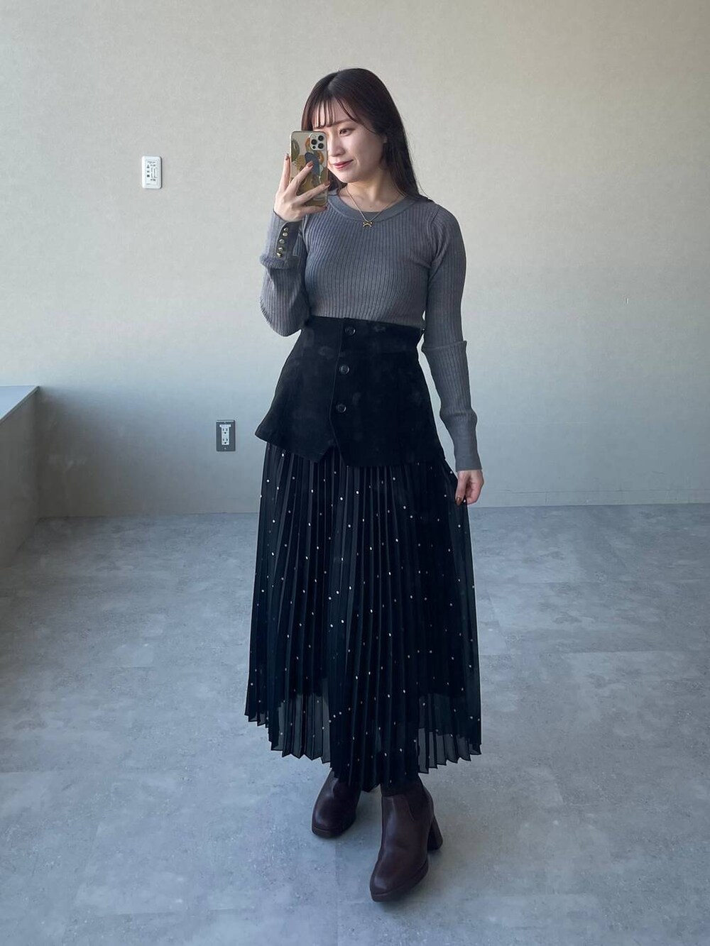 ホワイト系のチェスターコート、ブラウン系のブーツ、グレー系のニット/セーターを着用したレディースの冬コーディネートの4枚目の写真