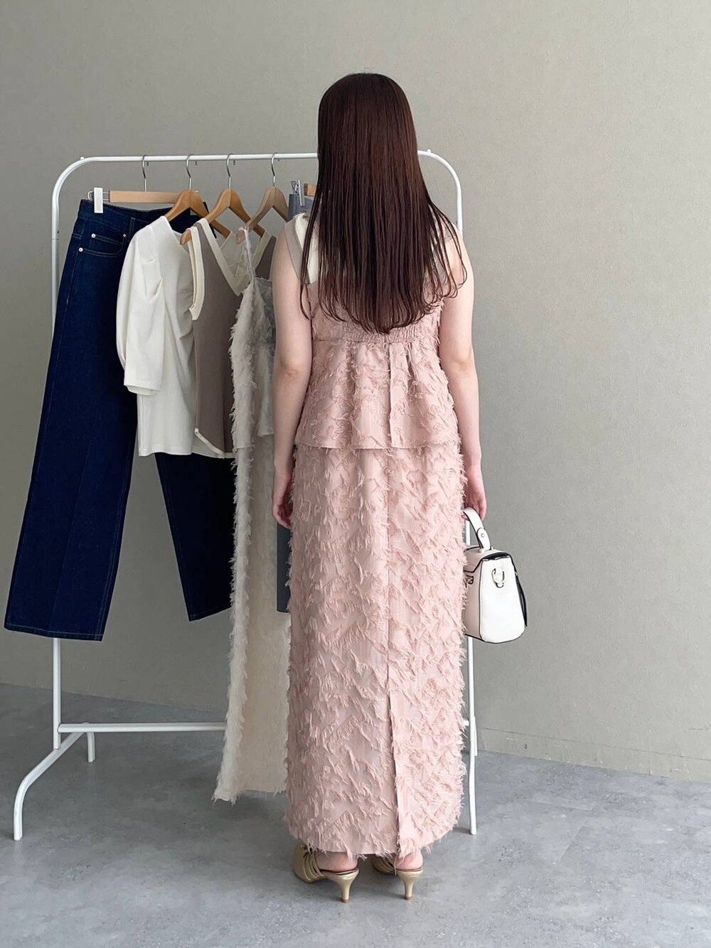 ゴールド系のパンプス、ホワイト系のショルダーバッグ、ホワイト系のタンクトップを着用したレディースの秋コーディネートの2枚目の写真