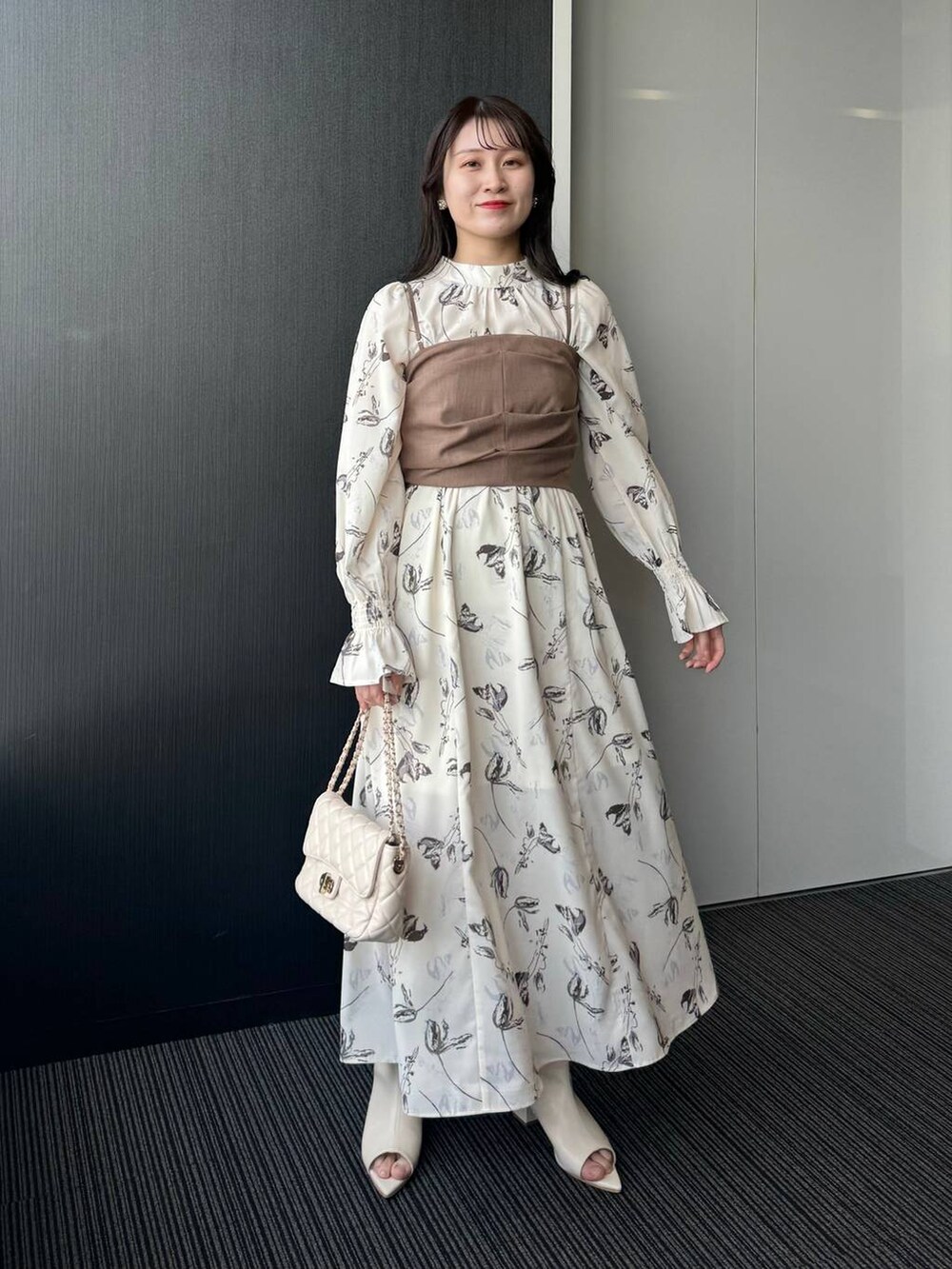 ホワイト系のショルダーバッグ、ホワイト系のワンピース、ホワイト系のブーツを着用したレディースの冬コーディネートの2枚目の写真