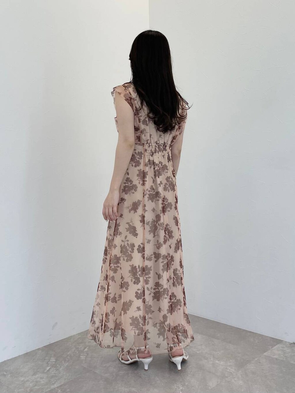 ホワイト系のハンドバッグ、ホワイト系のサンダル、ベージュ系のワンピースを着用したレディースの春コーディネートの2枚目の写真