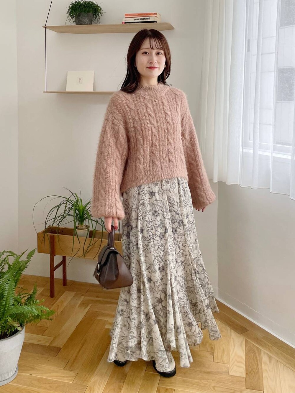 ブラック系のチェスターコート、ホワイト系のブーツ、ベージュ系のスカートを着用したレディースの秋コーディネートの4枚目の写真