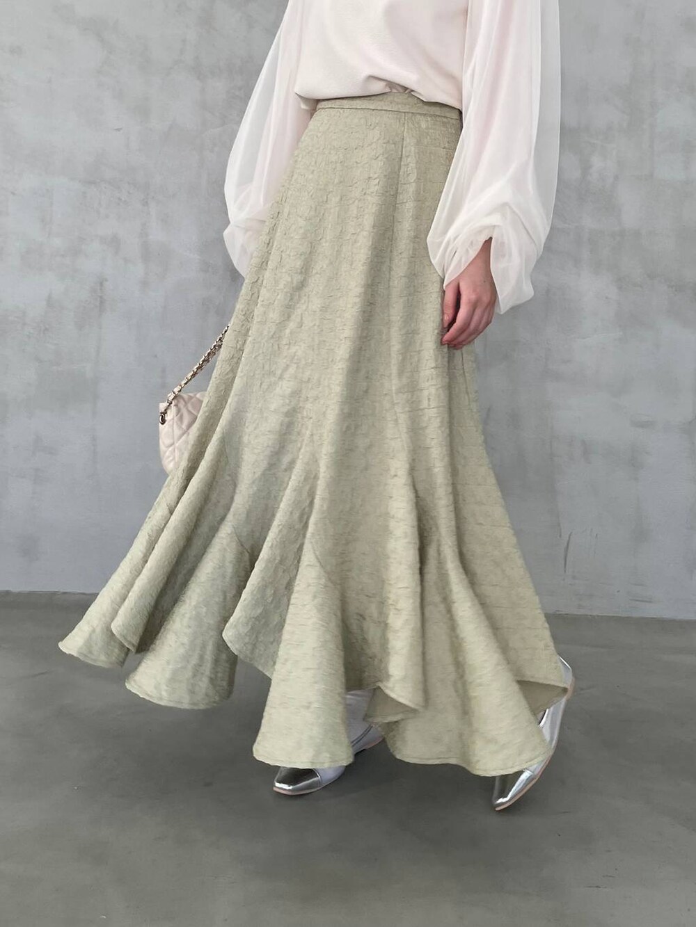 ホワイト系のTシャツ/カットソー、ホワイト系のショルダーバッグ、グリーン系のスカートを着用したレディースの冬コーディネートの4枚目の写真