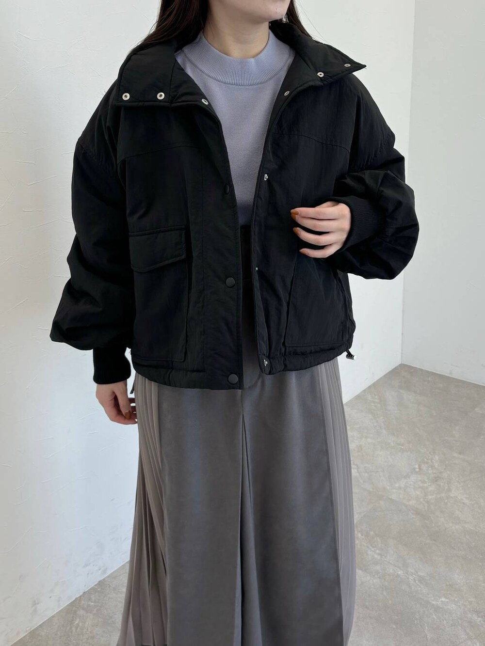 ブラック系のブーツ、ブラック系のブルゾン、ブラック系のショルダーバッグを着用したレディースの冬コーディネートの3枚目の写真