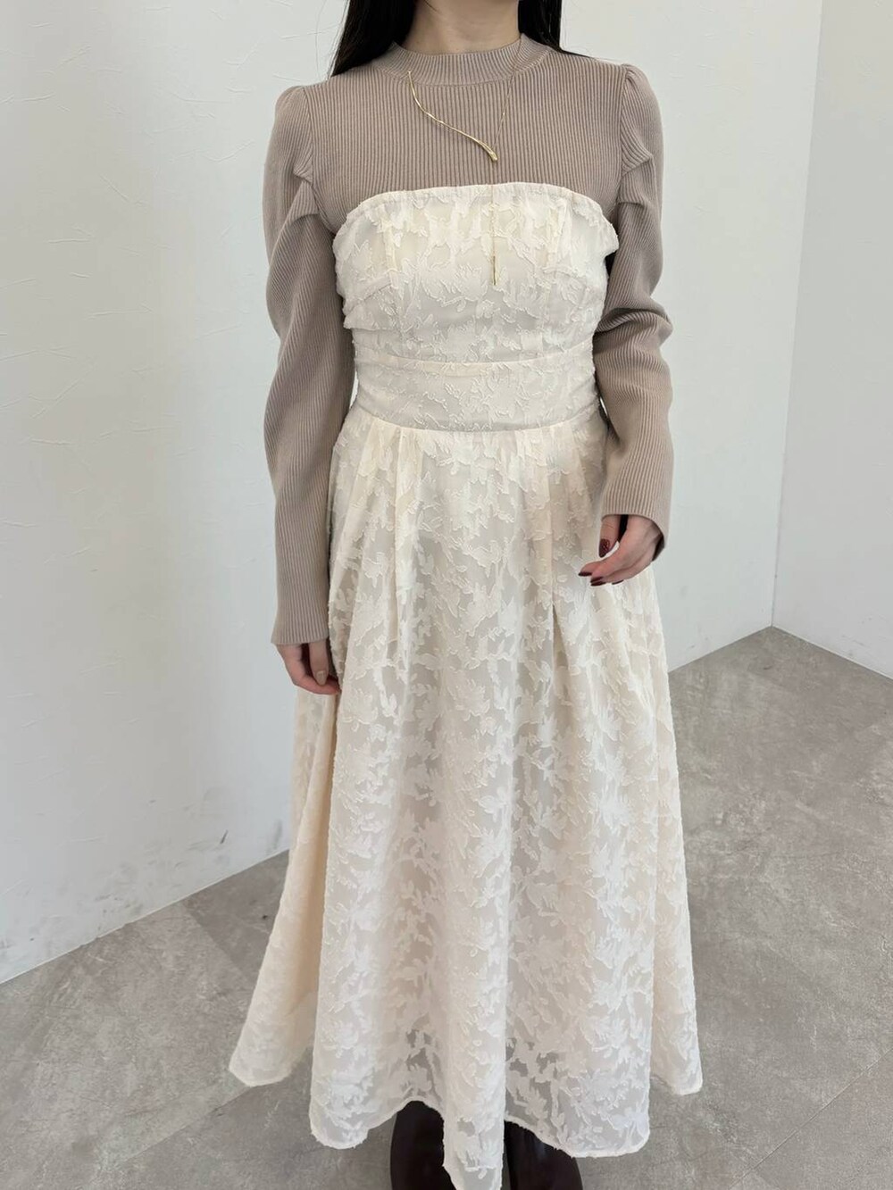 ブラウン系のブーツ、ブラウン系のハンドバッグ、ホワイト系のワンピースを着用したレディースの冬コーディネートの3枚目の写真