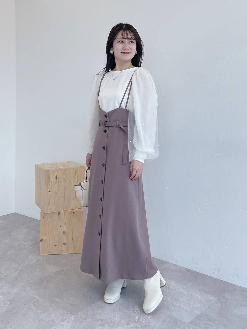 ブラウン系のチェスターコート、ホワイト系のハンドバッグ、ホワイト系のブーツを着用したレディースの夏コーディネートの5枚目の写真