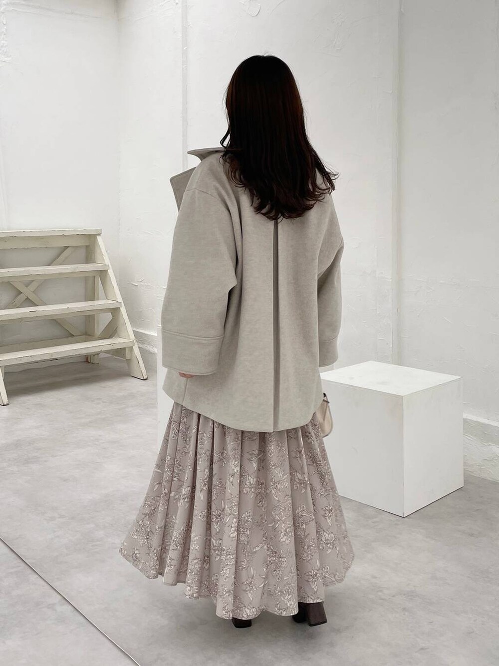 ホワイト系のハンドバッグ、ブラウン系のニット/セーター、ブラウン系のブーツを着用したレディースの秋コーディネートの2枚目の写真