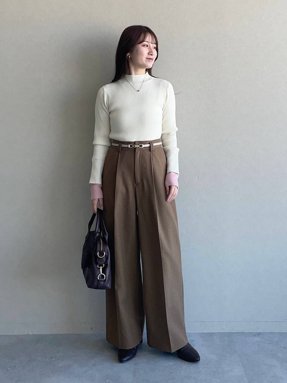 ホワイト系のピーコート、ブラウン系のボストンバッグ、ブラウン系のブーツを着用したレディースの冬コーディネートの3枚目の写真