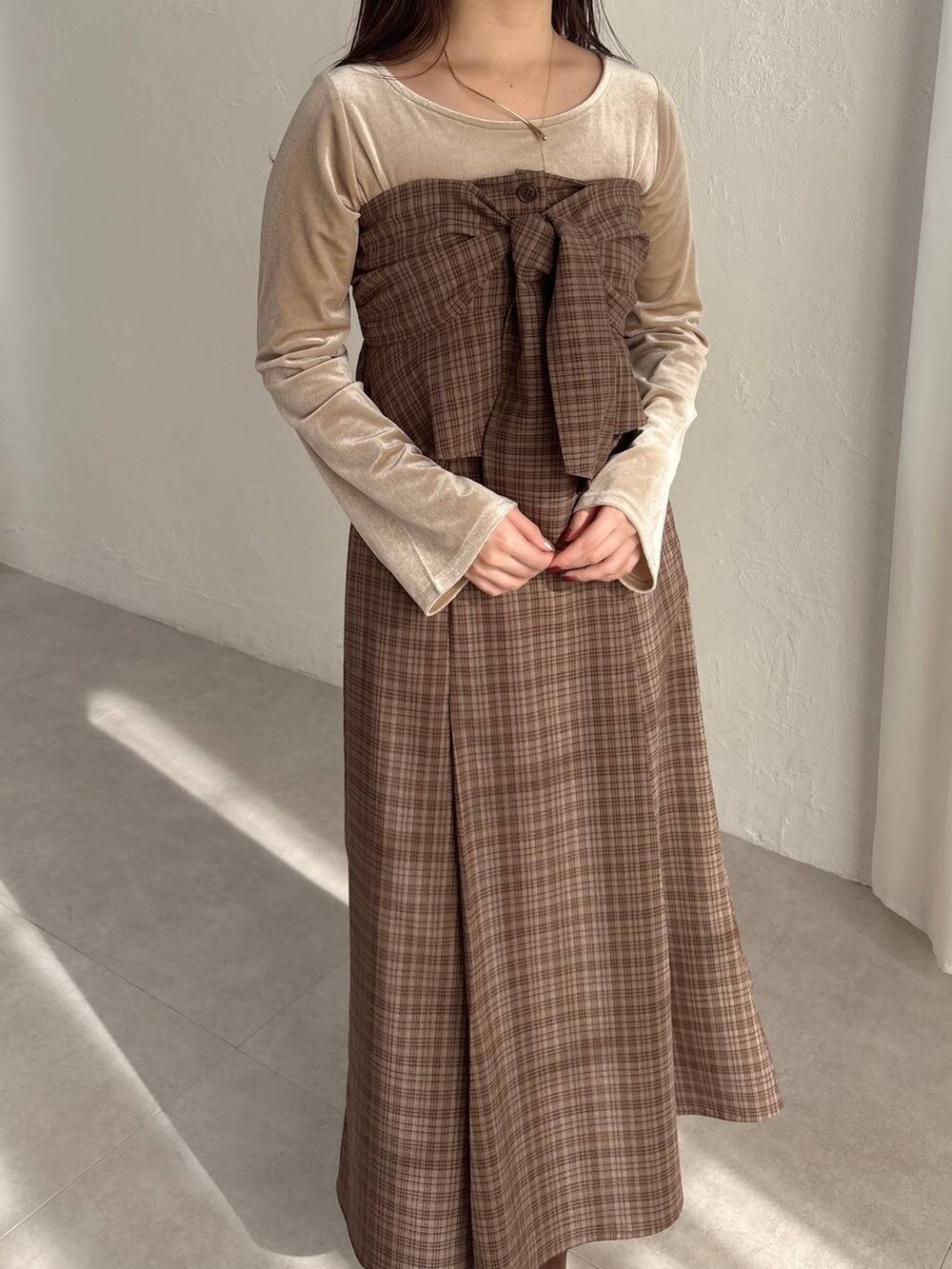 ブラウン系のブーツ、ブラウン系のスカート、ベージュ系のTシャツ/カットソーを着用したレディースの冬コーディネートの3枚目の写真