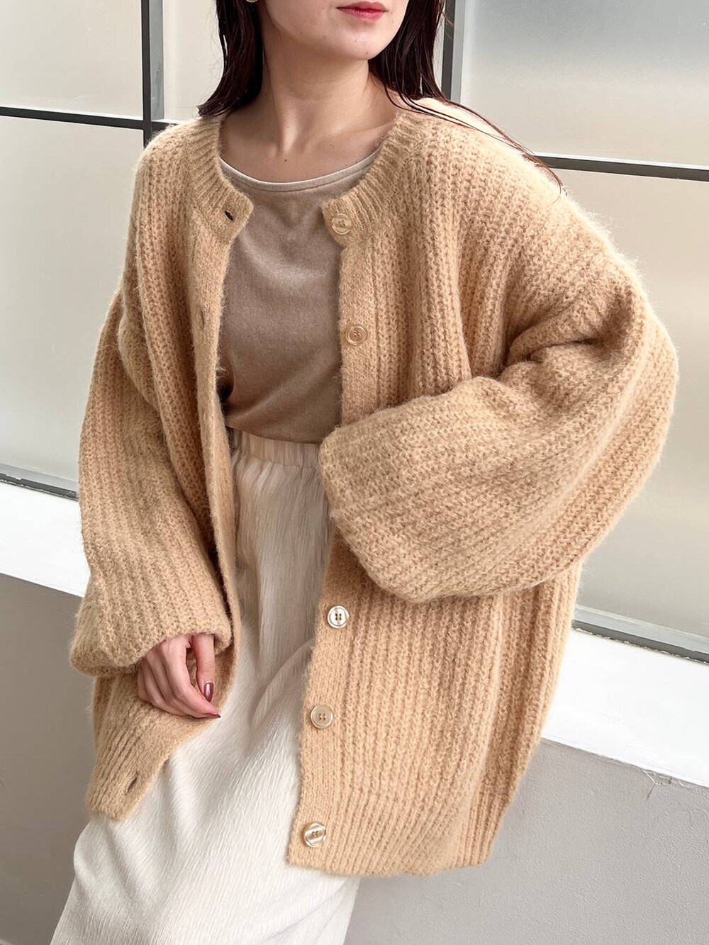 ブラウン系のブーツ、ベージュ系のカーディガン/ボレロ、ベージュ系のTシャツ/カットソーを着用したレディースの秋コーディネートの3枚目の写真