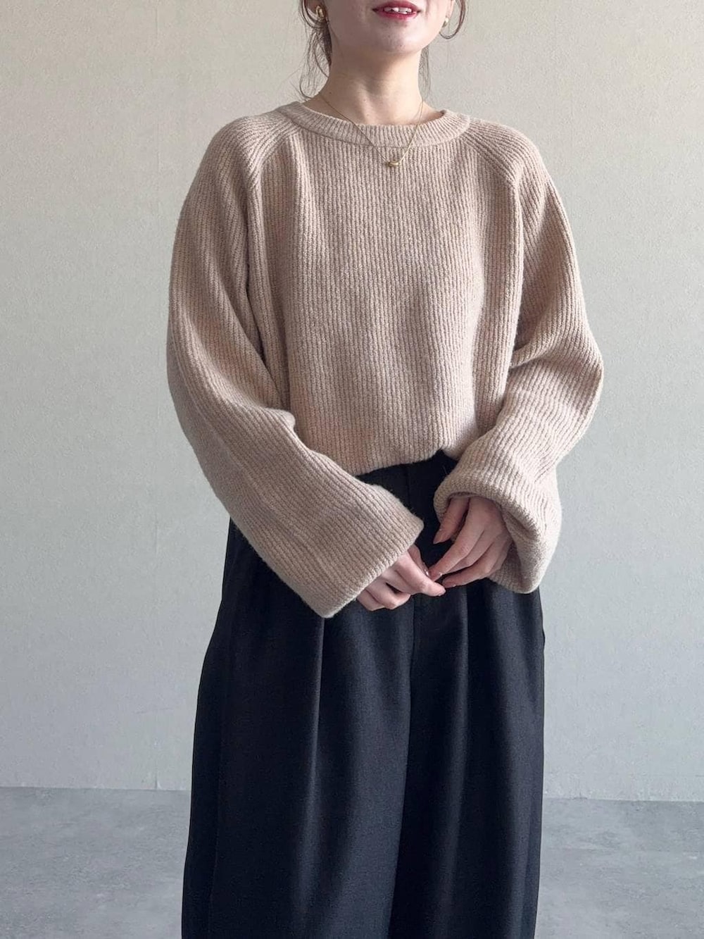 ベージュ系のニット/セーター、ブラック系のハンドバッグ、ブラック系のサンダルを着用したレディースの冬コーディネートの3枚目の写真