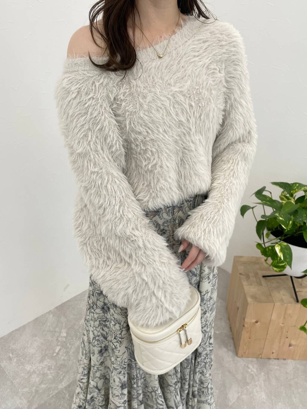 ホワイト系のブーツ、ベージュ系のスカート、ホワイト系のショルダーバッグを着用したレディースの冬コーディネートの6枚目の写真