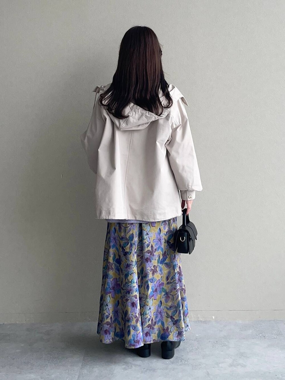 イエロー系のスカート、ベージュ系のマウンテンパーカー、パープル系のニット/セーターを着用したレディースの秋コーディネートの2枚目の写真