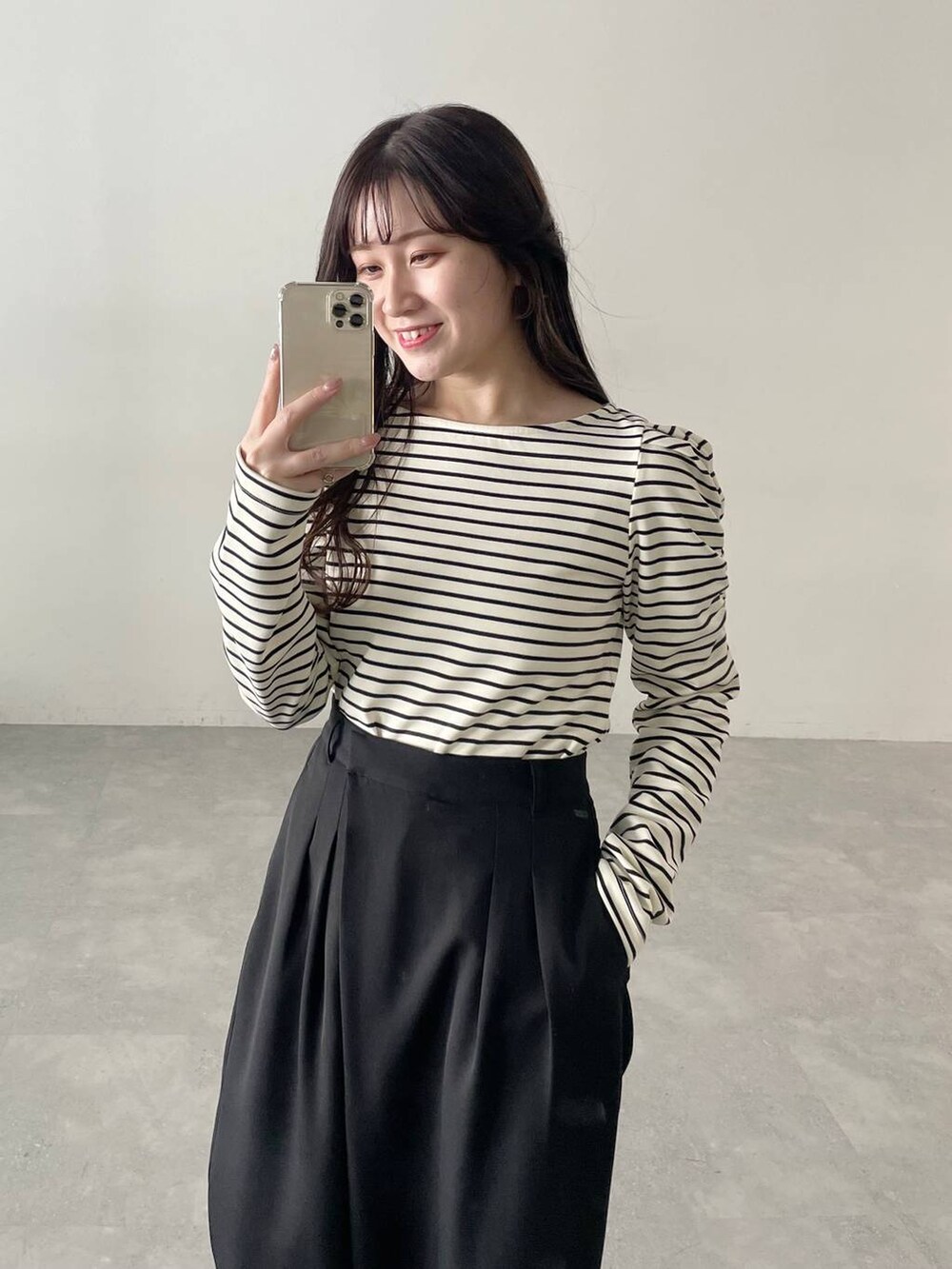 ホワイト系のショルダーバッグ、ブラック系のパンプス、ブラック系のスラックスを着用したレディースの春コーディネートの3枚目の写真