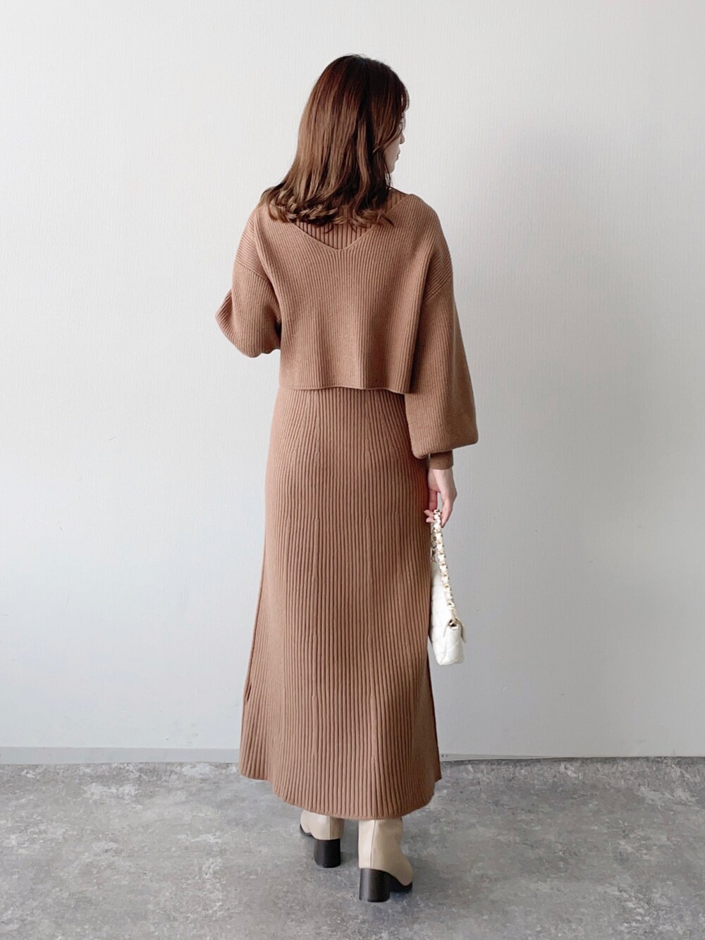 ブラウン系のワンピース、ホワイト系のショルダーバッグ、ベージュ系のブーツを着用したレディースの秋コーディネートの2枚目の写真