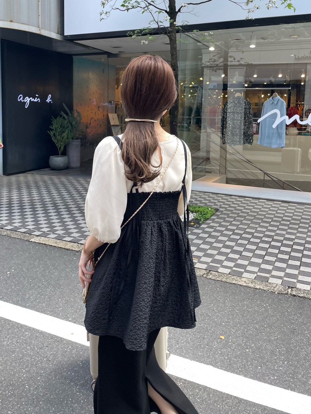 ブラウン系のショルダーバッグ、ホワイト系のシャツ/ブラウス、ブラック系のキャミソールを着用したレディースの春コーディネートの2枚目の写真