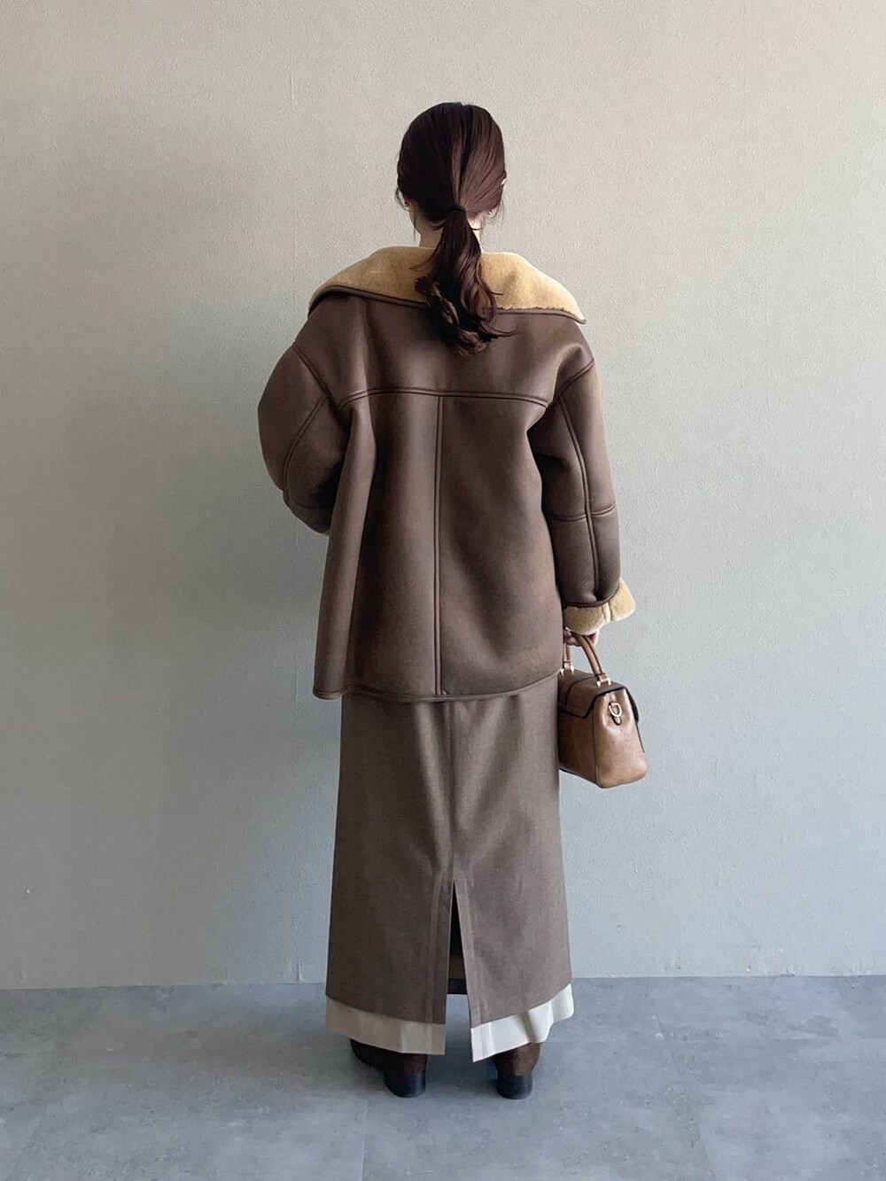 グリーン系のニット/セーター、ブラウン系のローファー、ブラウン系のブルゾンを着用したレディースの冬コーディネートの2枚目の写真