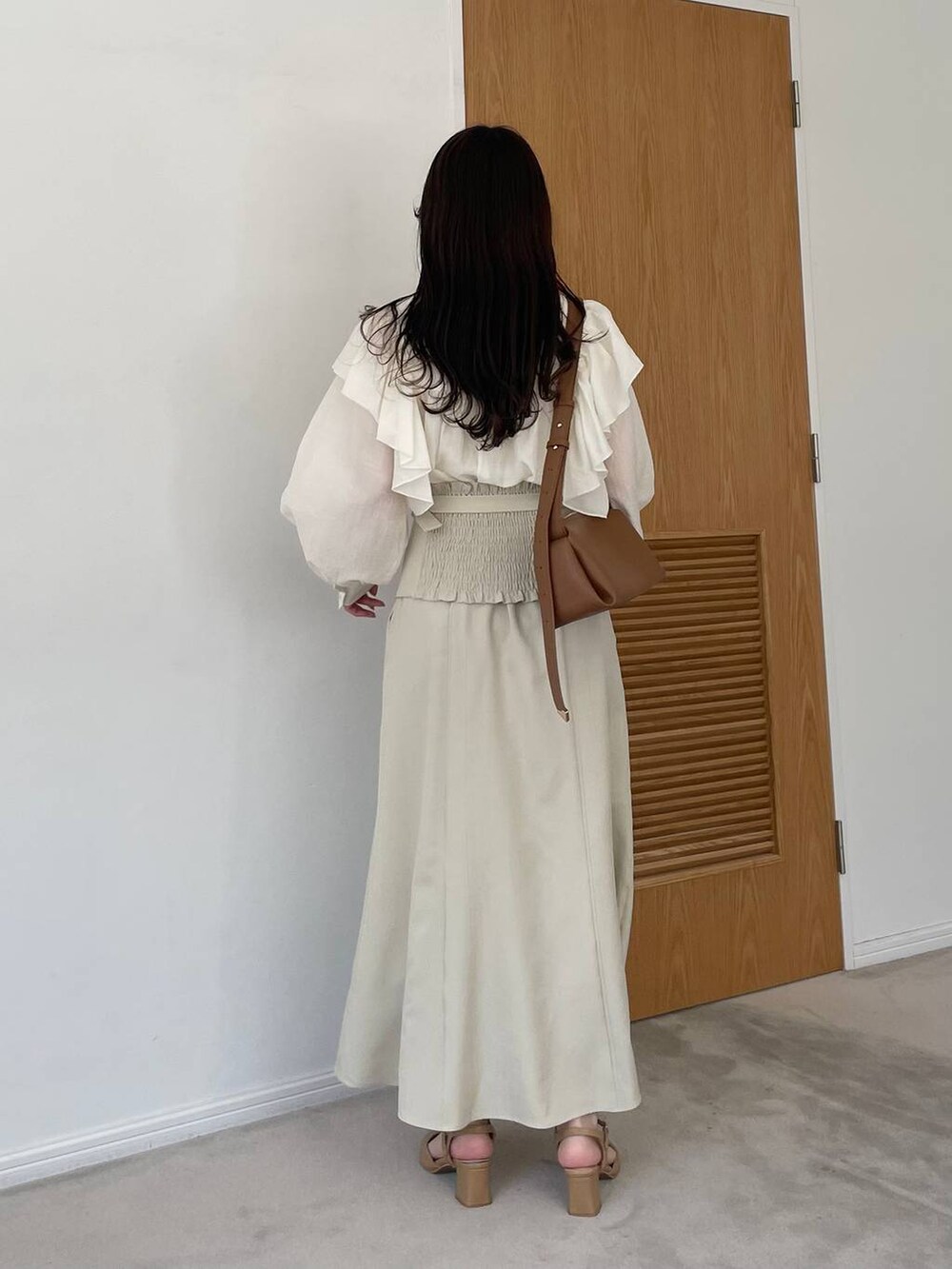 ホワイト系のスカート、ベージュ系のパンプス、ホワイト系のシャツ/ブラウスを着用したレディースの春コーディネートの2枚目の写真