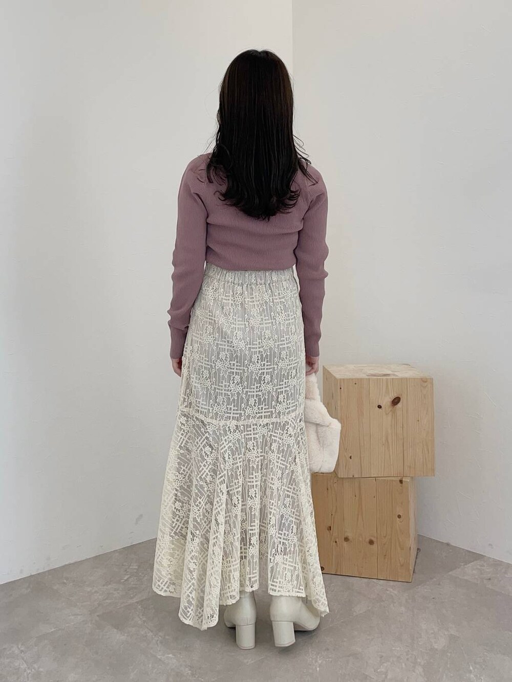 ホワイト系のブーツ、ホワイト系のスカート、ホワイト系のハンドバッグを着用したレディースの秋コーディネートの2枚目の写真