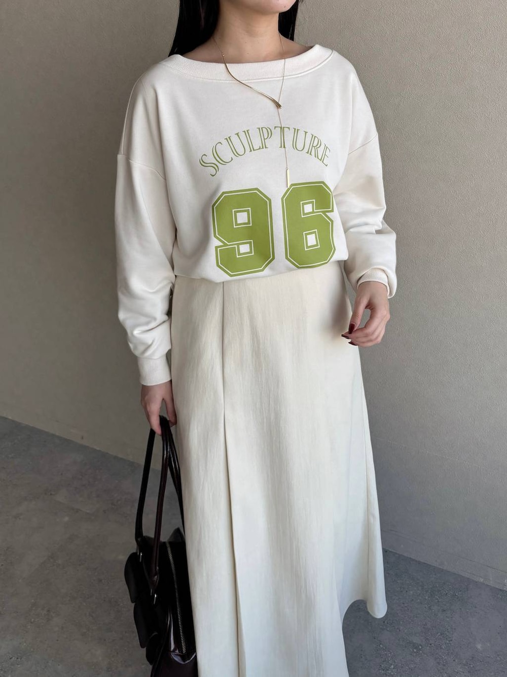 ホワイト系のブーツ、ブラウン系のハンドバッグ、ホワイト系のスウェットを着用したレディースの冬コーディネートの3枚目の写真