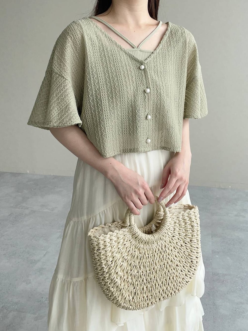 グリーン系のカーディガン/ボレロ、ブラウン系のサンダル、ホワイト系のスカートを着用したレディースの夏コーディネートの3枚目の写真