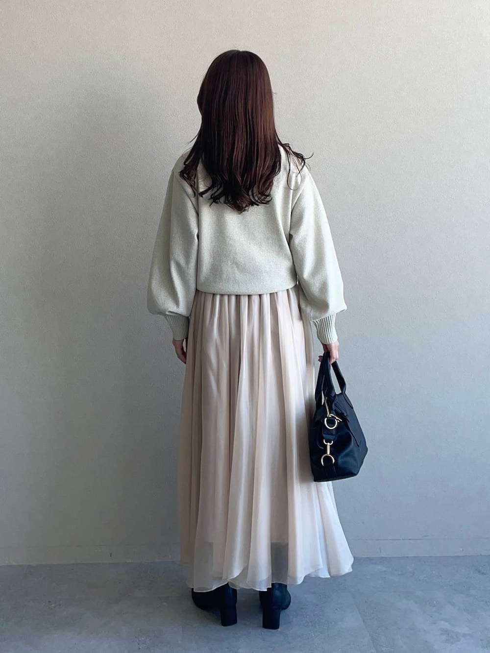 グレー系のピーコート、ホワイト系のニット/セーター、ブラック系のボストンバッグを着用したレディースの冬コーディネートの4枚目の写真