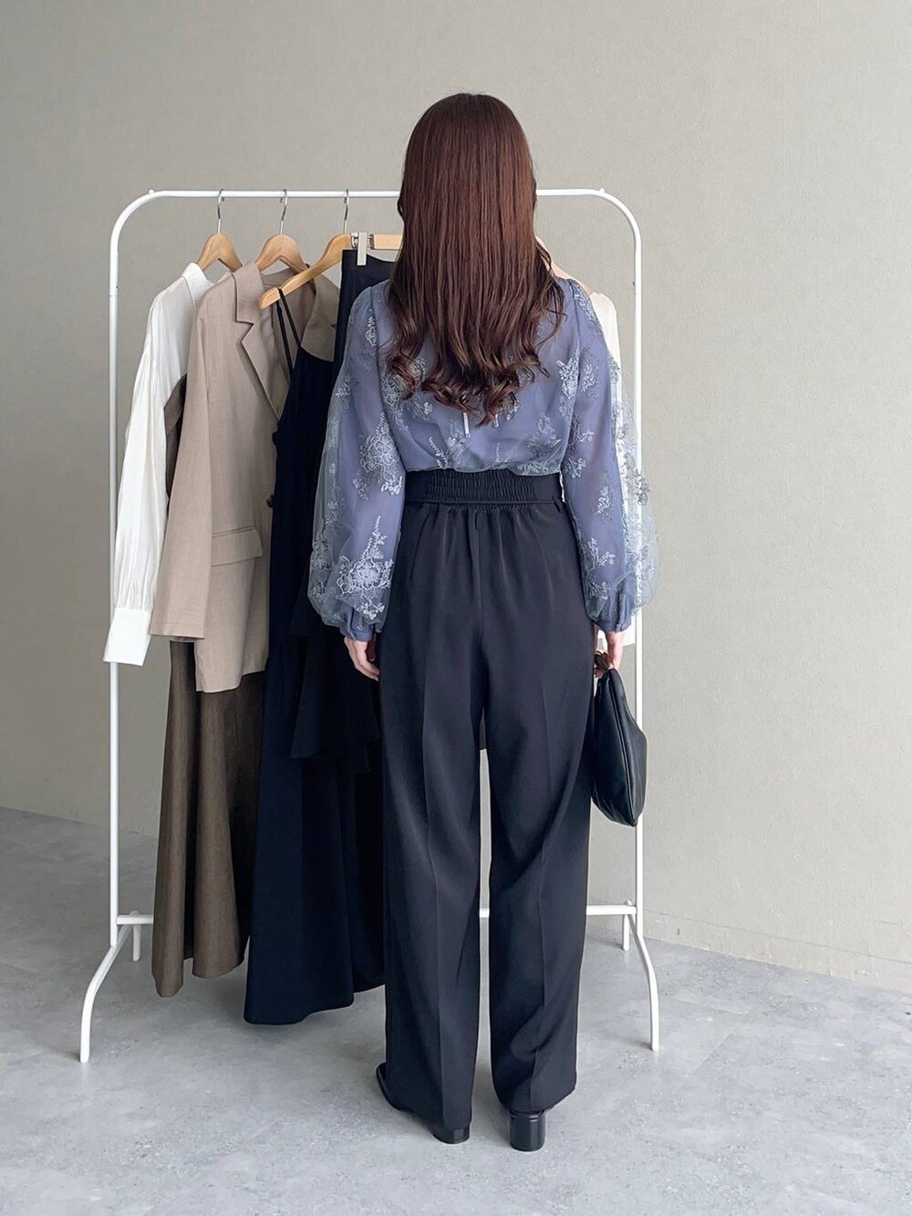 ブラック系のハンドバッグ、ブルー系のシャツ/ブラウス、ブラック系のその他パンツを着用したレディースの秋コーディネートの2枚目の写真