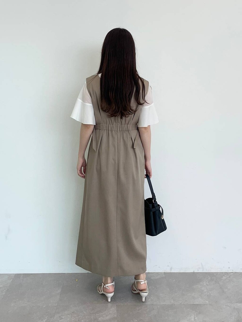 ホワイト系のTシャツ/カットソー、ホワイト系のサンダル、ブラック系のショルダーバッグを着用したレディースの夏コーディネートの2枚目の写真