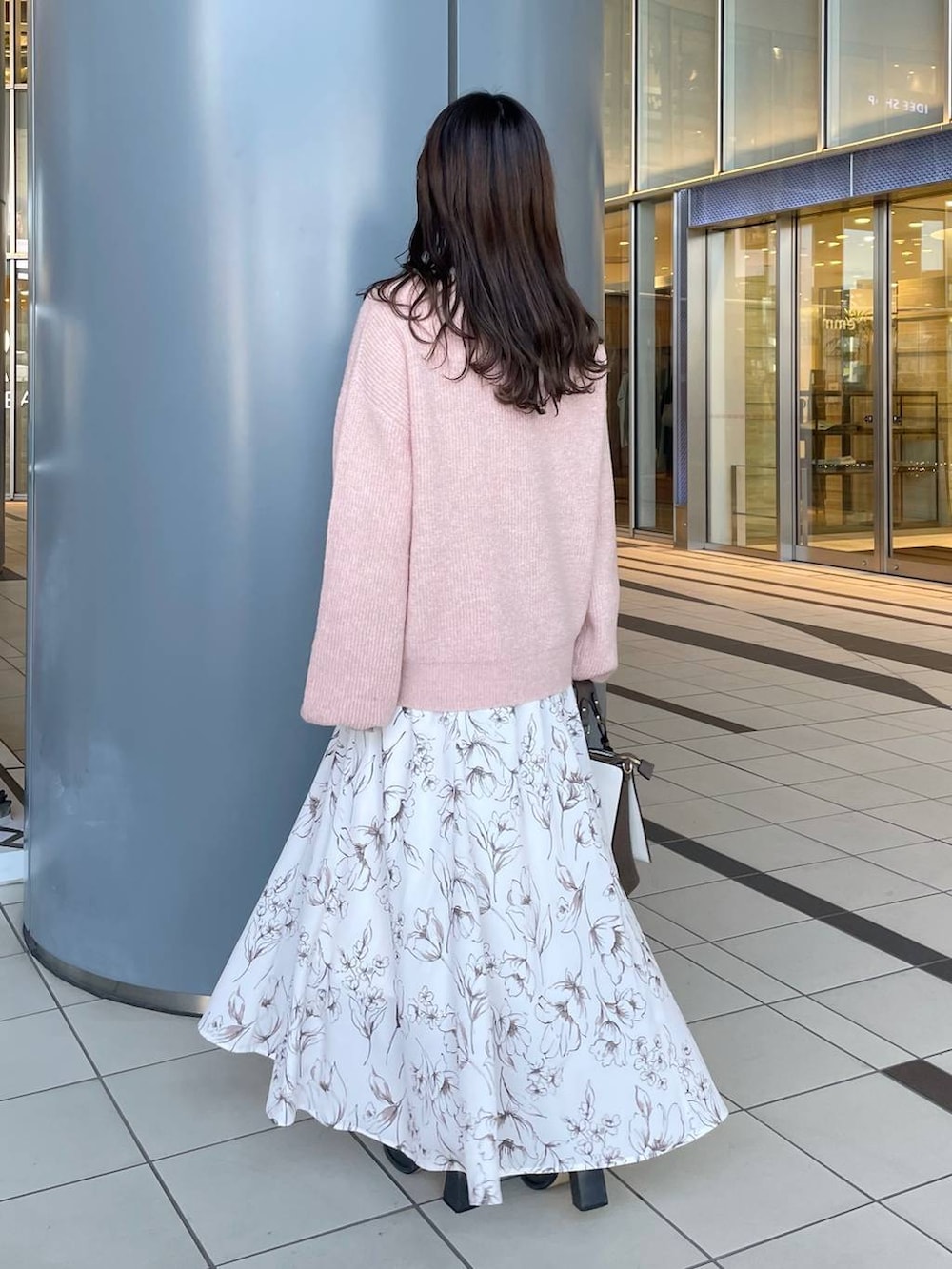 ピンク系のニット/セーター、グレー系のブーツ、ホワイト系のトートバッグを着用したレディースの冬コーディネートの2枚目の写真