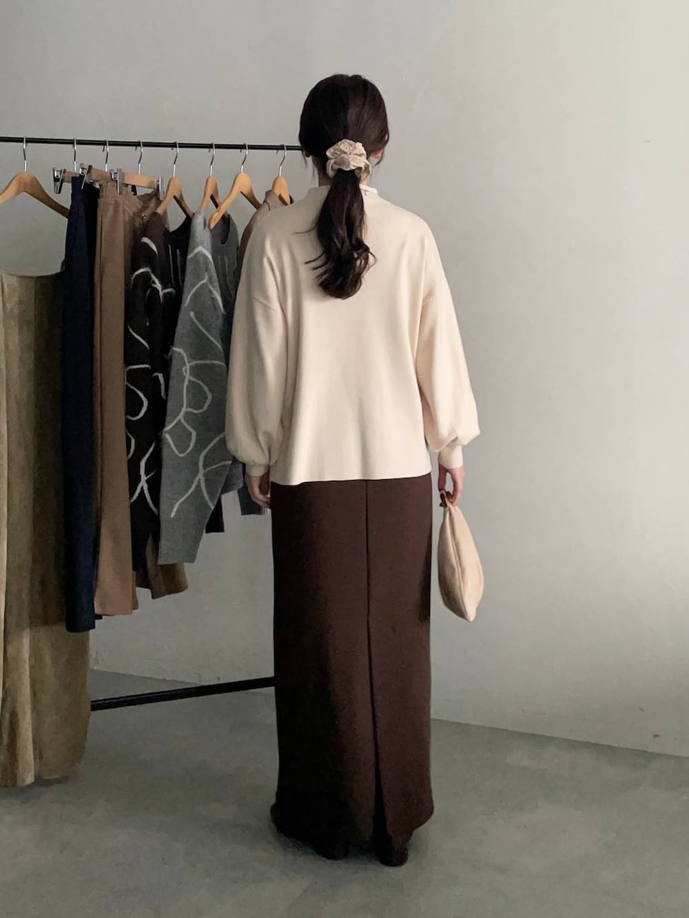 ベージュ系のハンドバッグ、ベージュ系のテーラードジャケット、ブラウン系のスカートを着用したレディースの秋コーディネートの4枚目の写真