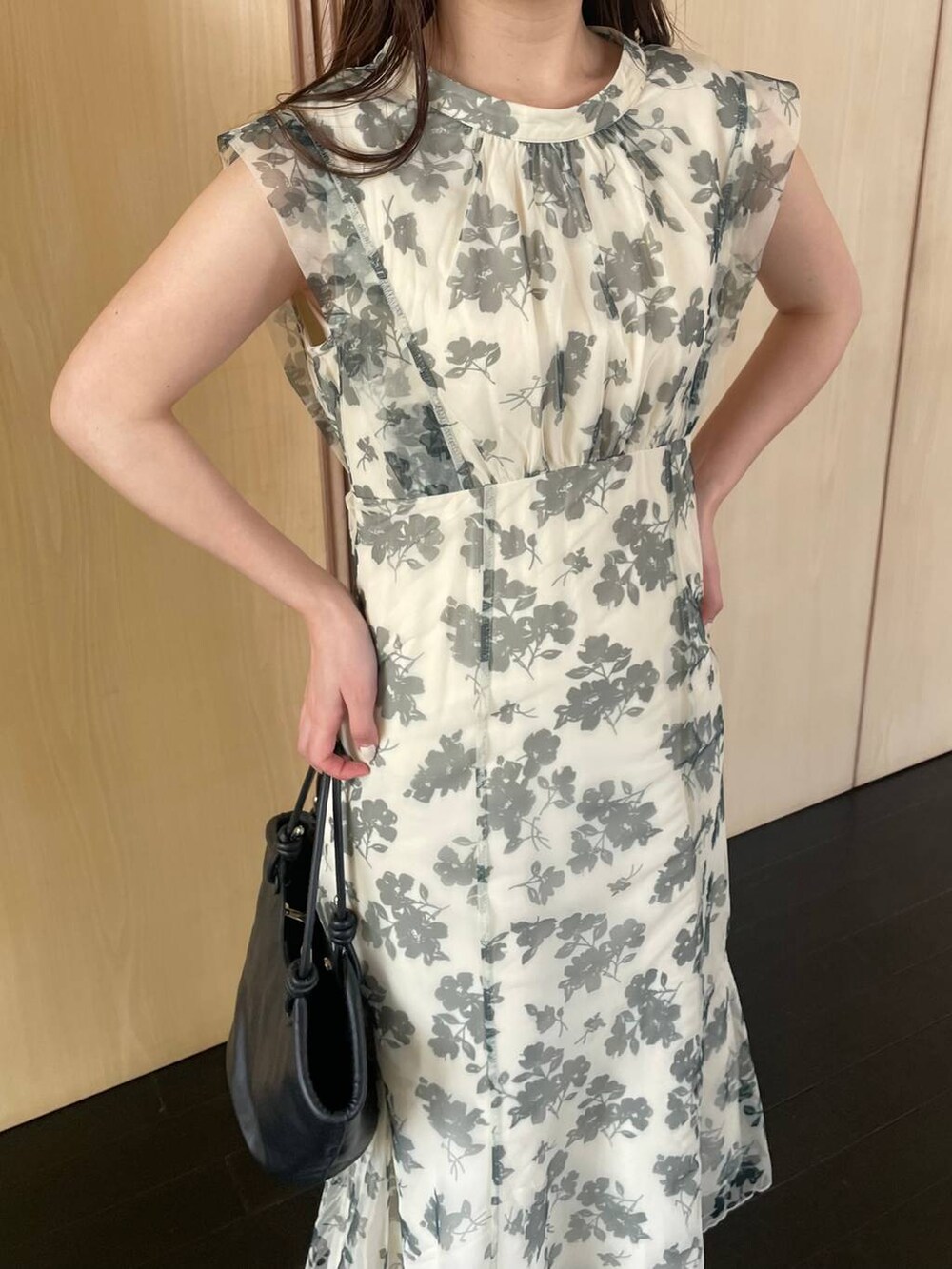 ブラック系のハンドバッグ、ブラック系のサンダル、ホワイト系のワンピースを着用したレディースの春コーディネートの3枚目の写真