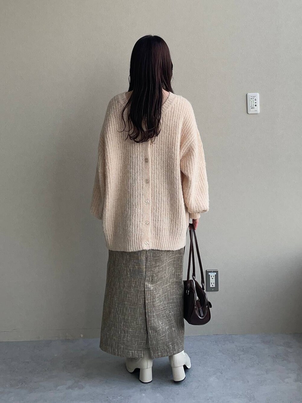 ホワイト系のブーツ、ホワイト系のカーディガン/ボレロ、ホワイト系のハンドバッグを着用したレディースの秋コーディネートの4枚目の写真