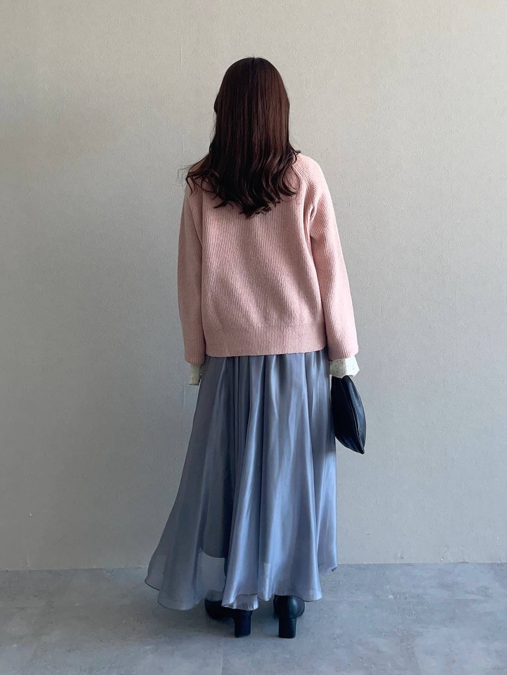 ピンク系のニット/セーター、ブラック系のハンドバッグ、ブラック系のブーツを着用したレディースの冬コーディネートの4枚目の写真