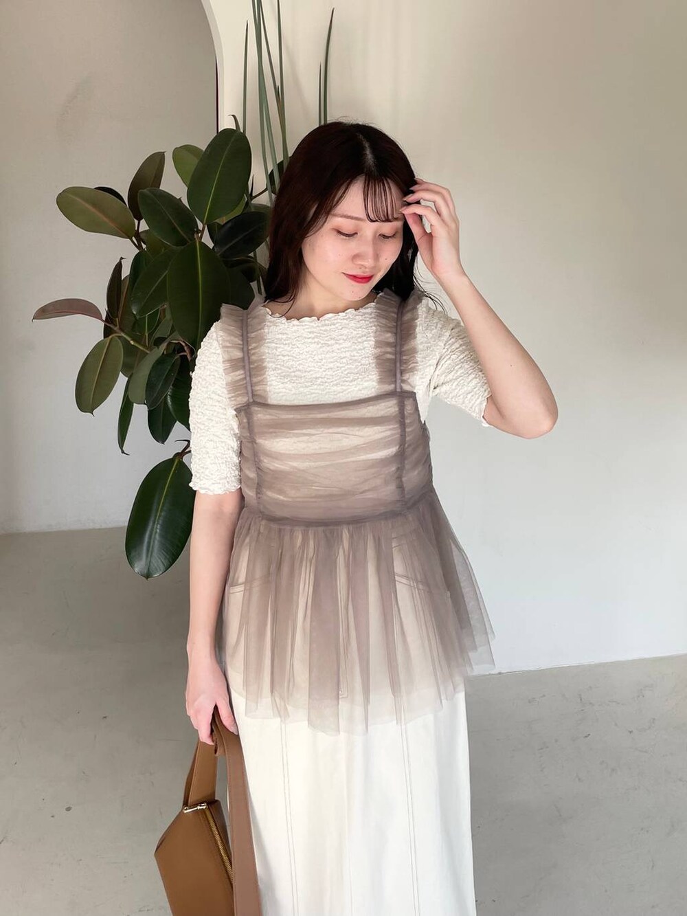 ホワイト系のスカート、ベージュ系のキャミソール、ホワイト系のTシャツ/カットソーを着用したレディースの春コーディネートの3枚目の写真