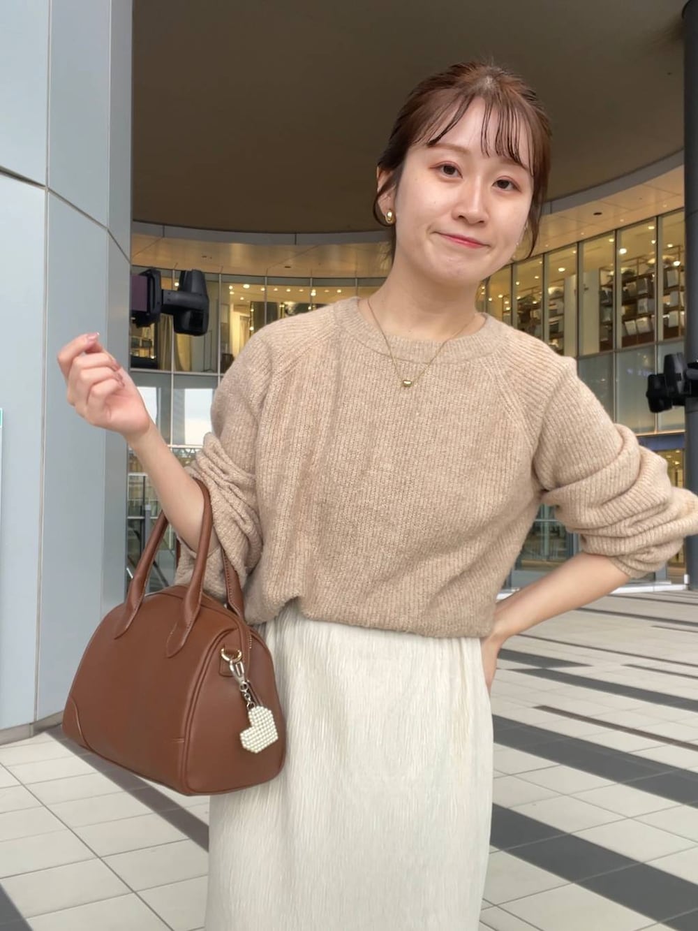 ベージュ系のニット/セーター、ホワイト系のブルゾンを着用したレディースの秋コーディネートの3枚目の写真