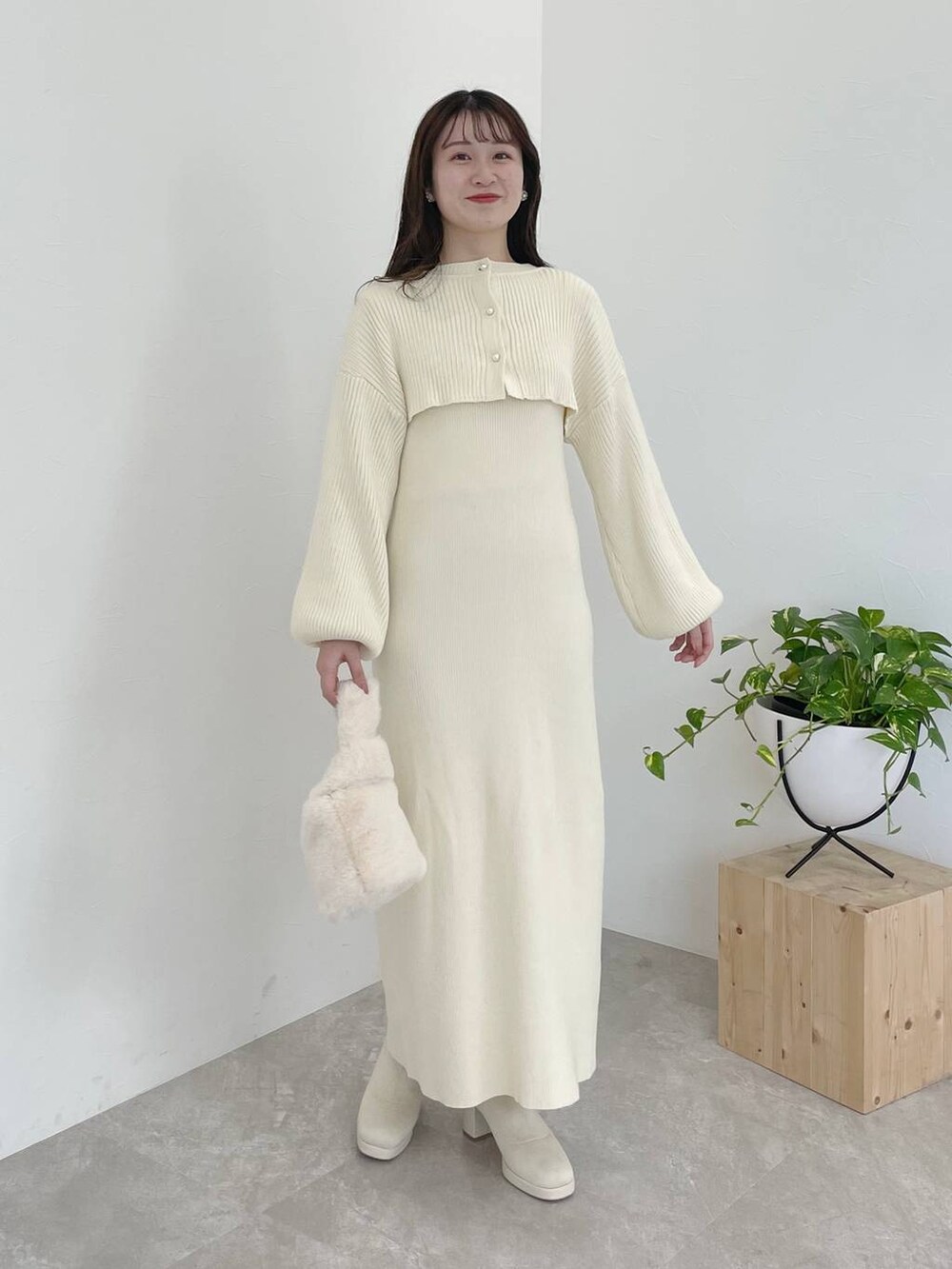 ホワイト系のブーツ、ホワイト系のハンドバッグ、ブラウン系のチェスターコートを着用したレディースの秋コーディネートの5枚目の写真