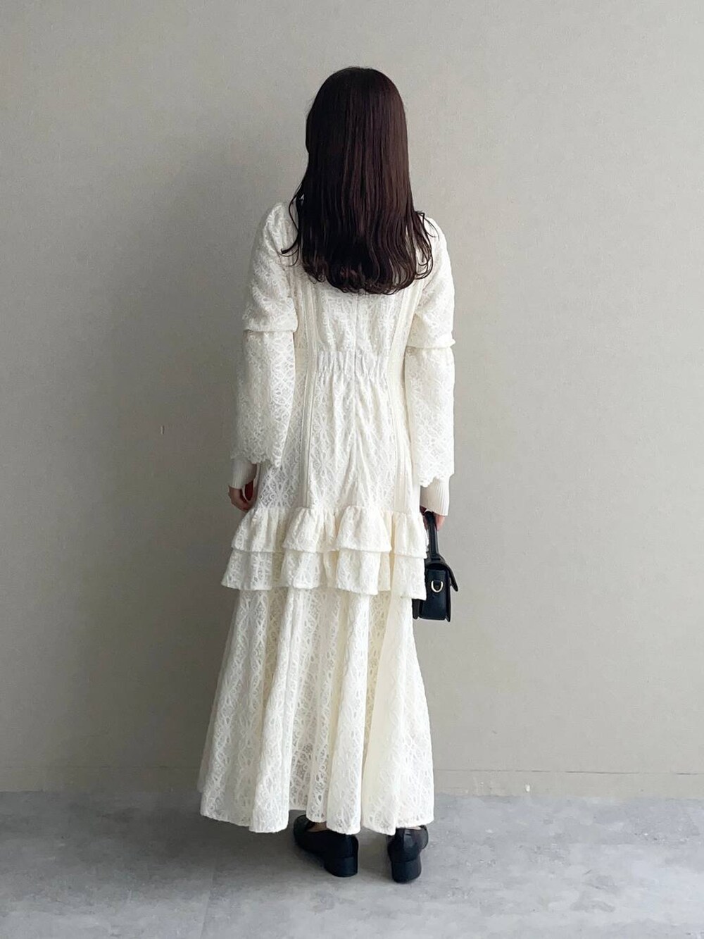 ホワイト系のニット/セーター、ホワイト系のワンピース、ブラック系のローファーを着用したレディースの秋コーディネートの4枚目の写真