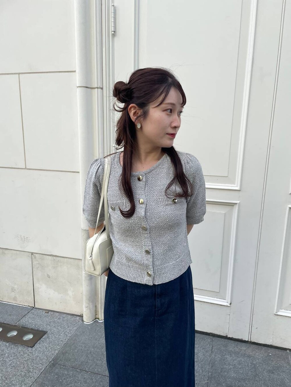 ベージュ系のパンプス、ブルー系のスカート、グレー系のカーディガン/ボレロを着用したレディースの春コーディネートの3枚目の写真