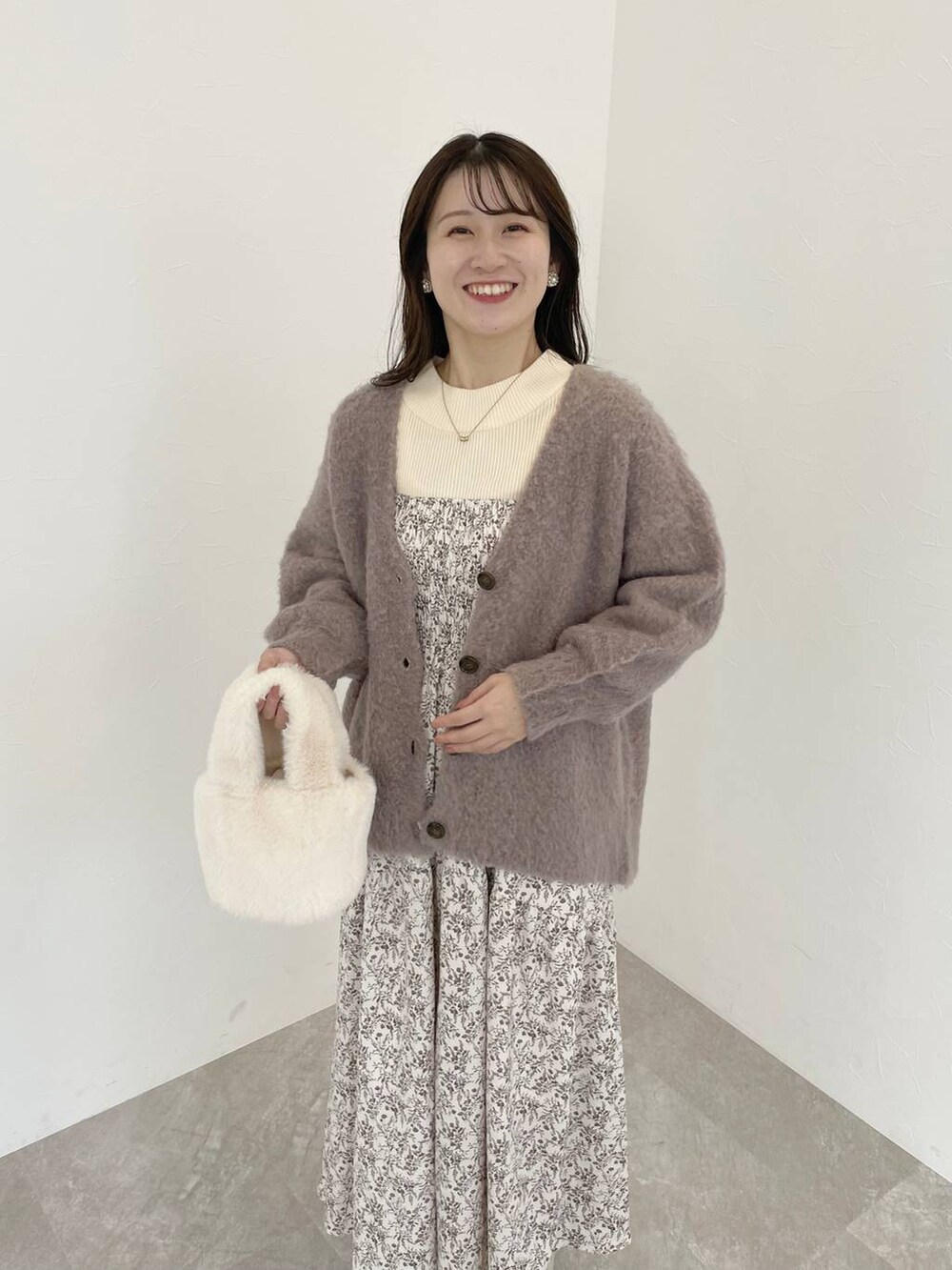 ホワイト系のブーツ、ホワイト系のニット/セーター、ブラウン系のカーディガン/ボレロを着用したレディースの秋コーディネートの3枚目の写真