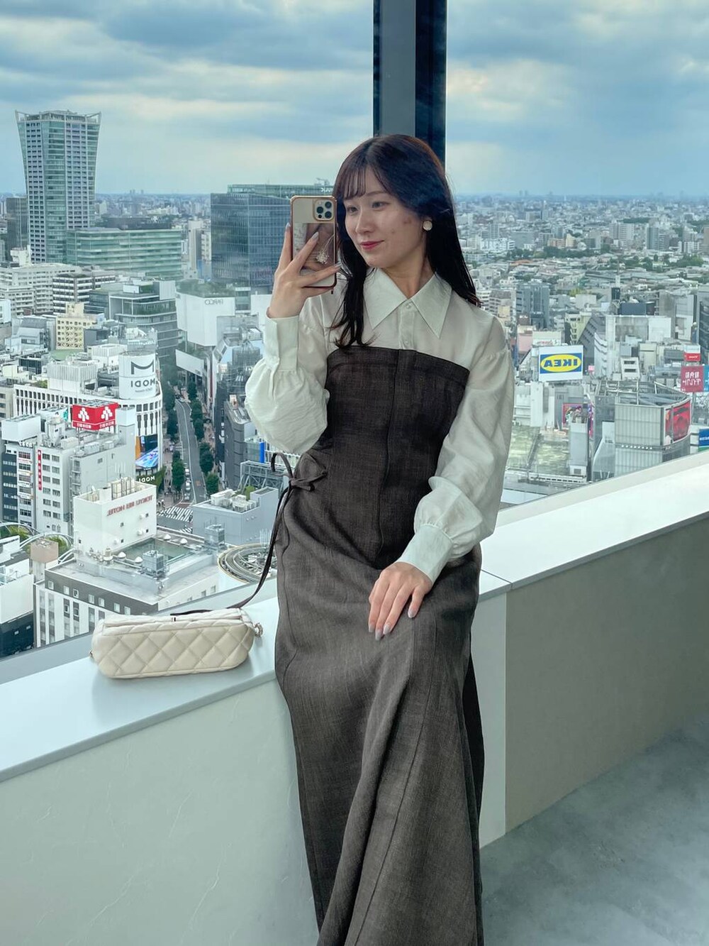 ホワイト系のブーツ、ブラウン系のワンピース、ホワイト系のショルダーバッグを着用したレディースの秋コーディネートの4枚目の写真