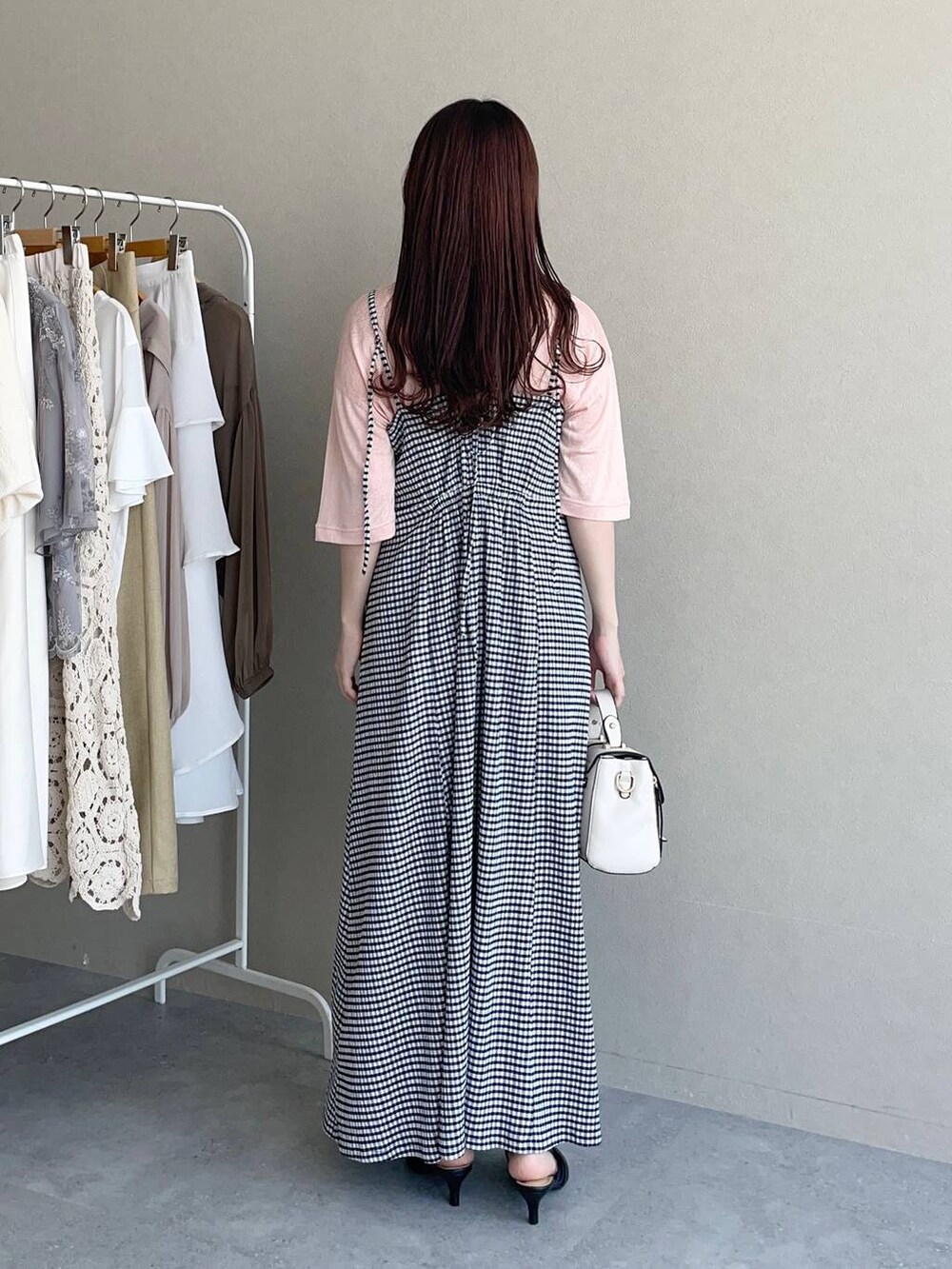 ブラック系のパンプス、ホワイト系のショルダーバッグ、その他のワンピースを着用したレディースの春コーディネートの2枚目の写真