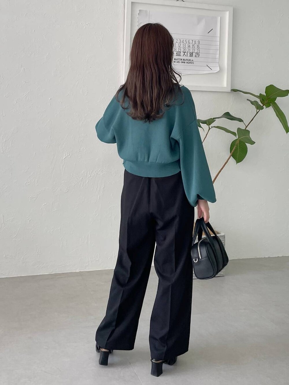 ブラック系のボストンバッグ、ブラック系のパンプス、グリーン系のカーディガン/ボレロを着用したレディースの夏コーディネートの2枚目の写真