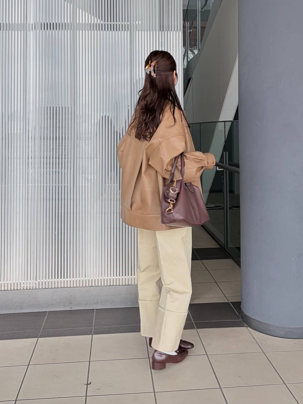 ブラウン系のボストンバッグ、ブラウン系のブルゾン、ブラック系のシャツ/ブラウスを着用したレディースの春コーディネートの2枚目の写真