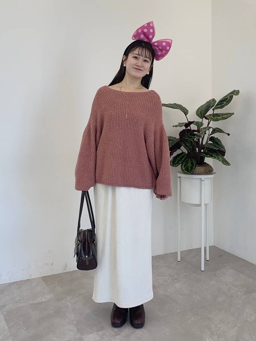 ブラウン系のブーツ、ホワイト系のスカート、ピンク系のニット/セーターを着用したレディースの冬コーディネートの3枚目の写真