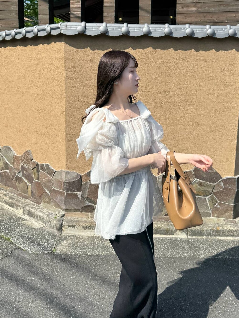 ブラック系のスカート、ホワイト系のシャツ/ブラウスを着用したレディースの春コーディネートの3枚目の写真